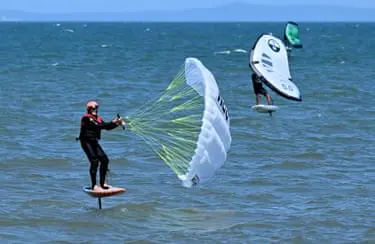 چندین نفر در حال وینگ‌سرف در دریا