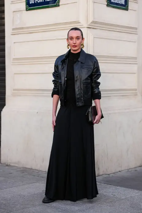 مهمان با گوشواره طلا، لباس ماکسی مشکی، جاکت چرمی براق مشکی و کیف براق مشکی