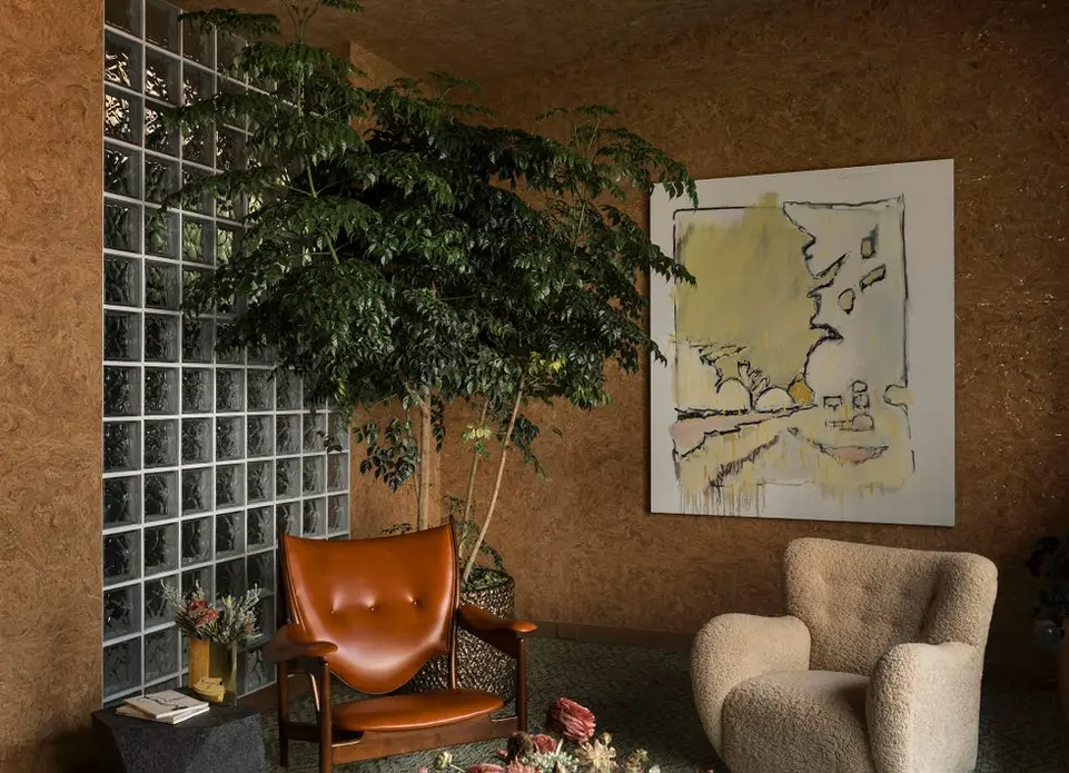 اتاقی با رنگ‌های گرم و دیوار شیشه‌ای مکعبی.